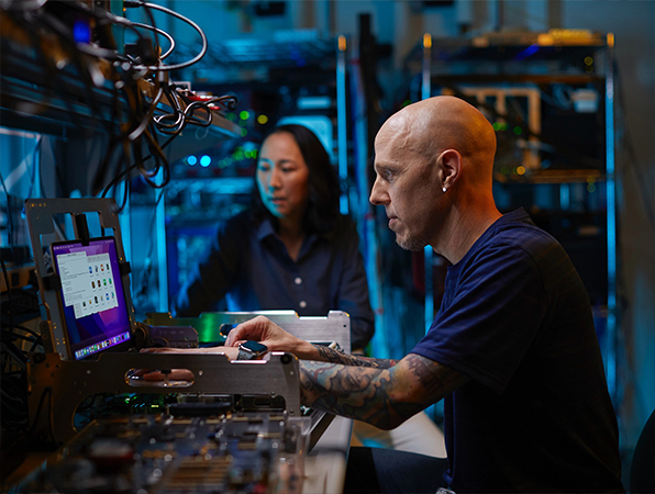 To medarbejdere fra Apple Hardware-teamet arbejder i et laboratorium.