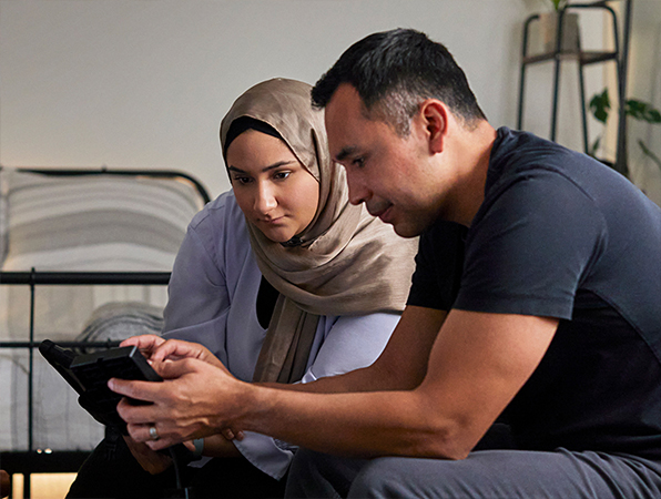 พนักงาน Apple ฝ่ายการเรียนรู้ของระบบและ AI 2 คนกำลังดู iPad อยู่