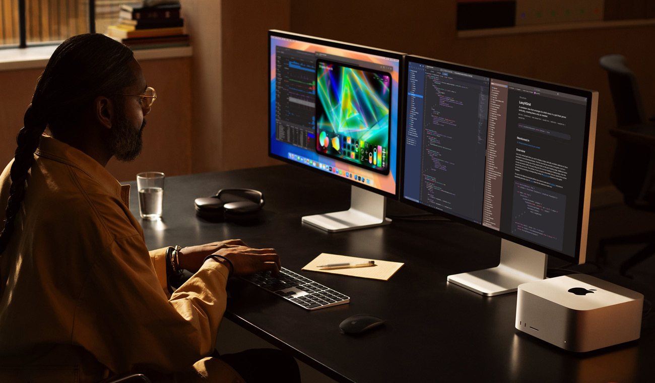Een professional werkt met Mac Studio en twee Studio Display-schermen