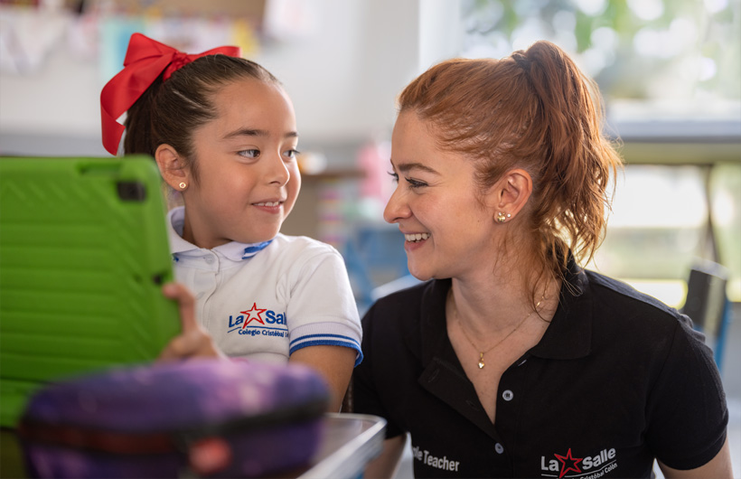 Eleane Ruth Guzmán Padilla sedang bersama seorang siswa di kelas di Colegio Cristobal Colón.