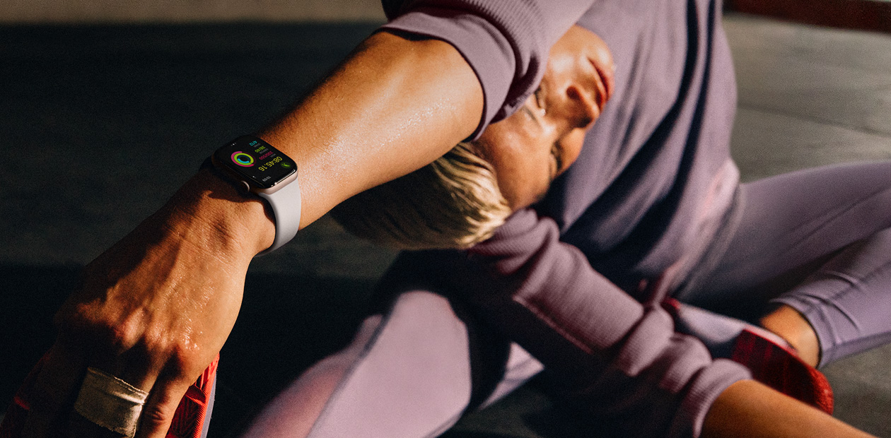Mulher usando o Apple Watch enquanto se alonga.